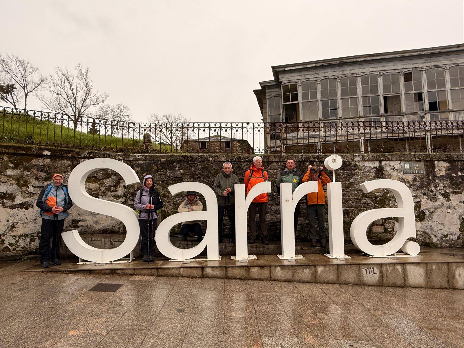 groepsfoto, wandelaars bij grote letters met de stadsnaam "Sarria"