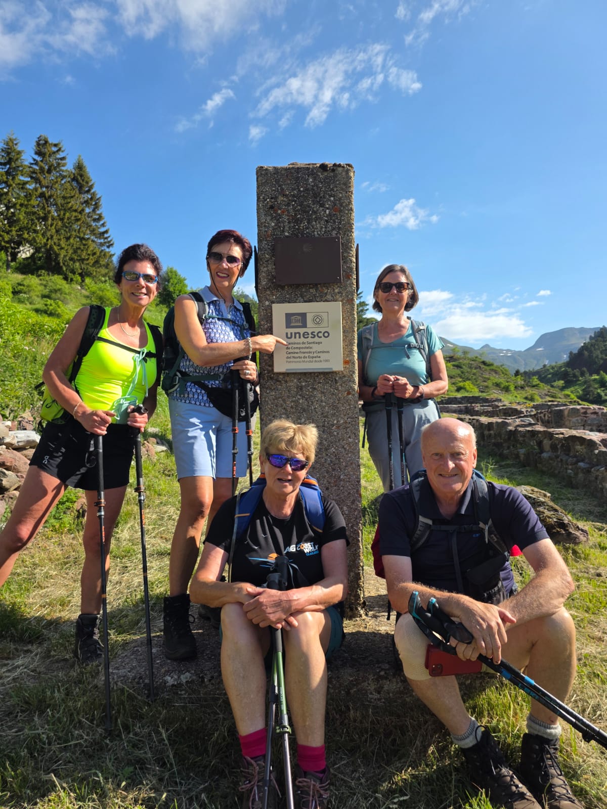 groep wandelaars bij paal op de camino met Unesco erfgoed bord