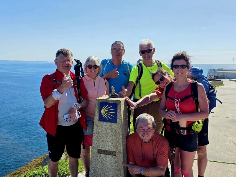 groep pelgrims bij kilometerpaal 0 op de camino te Fisterra